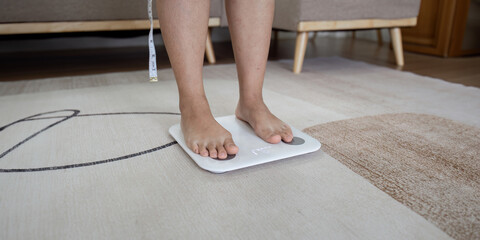 Over weight women weigh on scales to see results after exercise, healthy at home