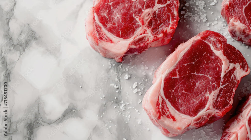 Wall mural Top view of ribeye steaks with coarse salt, on a marble background, perfect for high-end culinary themes