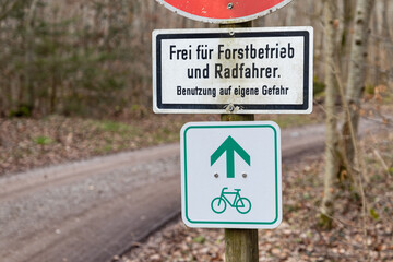 Verkehrszeichen kennzeichnet Radweg durch einen Wald