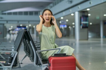 Asian woman chatting with friends while waiting at the transportation departure hall