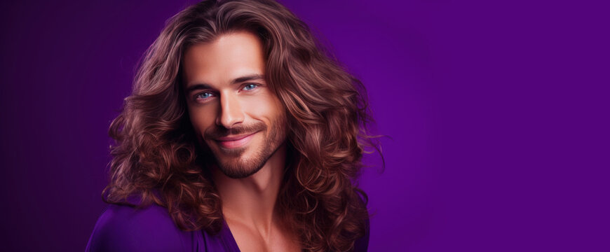 Handsome elegant sexy smiling Caucasian man with perfect skin and long hair, on a purple background, banner, close-up.