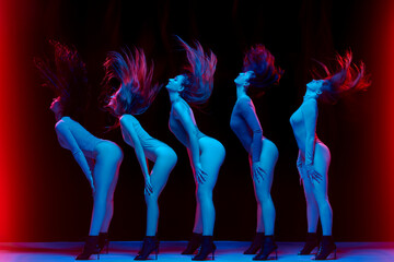 Impressive performance. Young women in bodysuits dancing on high heels against black background in...