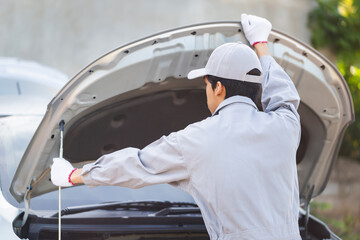 Technician man checks and fixes car air conditioner system, Auto mechanic repairs a car with an...