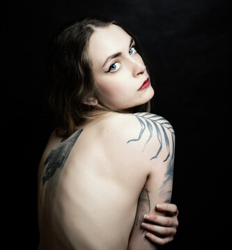 Portrait of beautiful sensual woman with tattoos, close-up. Studio shot.