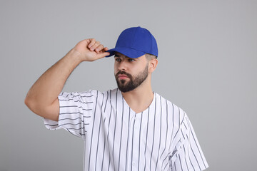 Man in stylish blue baseball cap on light grey background