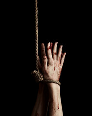 Woman implore hands tied with rope over black background. Horror movie scene