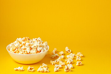 Fototapeta na wymiar plate with popcorn on a yellow background