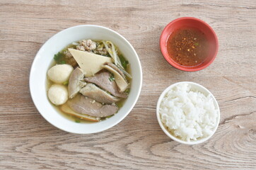 boiled soft slice pork and ball in clear soup on bowl eat couple plain rice