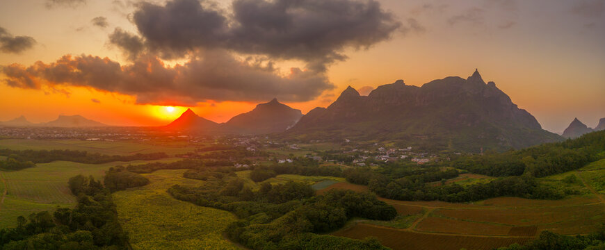 View of golden sunset behind Long Mountain and patchwork of green fields, Mauritius