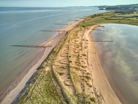 Aerial view of beach and dunes at Dawlish Warren, guarding the mouth of the River Exe, looking south along the coast towards the town of Dawlish, Devon, England