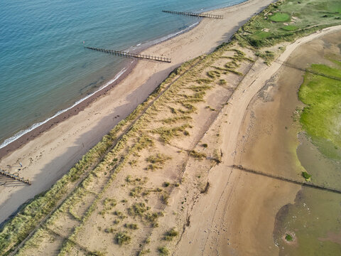 Aerial view of beach and dunes at Dawlish Warren, guarding the mouth of the River Exe, looking south along the coast towards the town of Dawlish, Devon, England