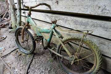 Rear view, the bicycle is rusty and damaged because it has not been used for a long time.