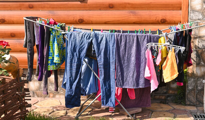 Washed clothes are hanging on the dryer in the yard of the house