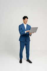 Professional man in blue suit stands confidently with a laptop, his posture relaxed and friendly, indicating ease of use with technology, successful outcome from digital interaction or remote working