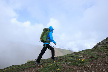 Woman hiker climbing to mountain top in tibet
