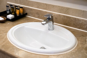 faucet for water and white sink on marble counter