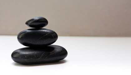 Black zen stones stacked on white background in wellness concept with free copyspace for text