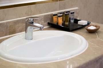 faucet for water and white sink on marble counter