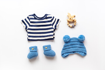 Set of baby boy dress - blue bodysuit with knitted hat and boots, top view. Kids clothing flat lay