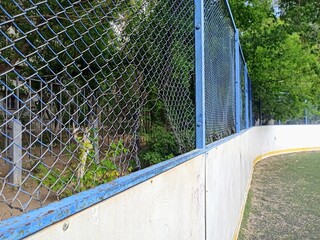 hole in the fence of a football field