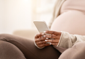 Cropped of pregnant black woman sitting on couch, using smartphone - Powered by Adobe