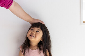 頭を撫でられて笑顔の女の子（3歳、日本人）