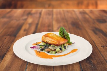 Fried tasty fish dish with vegetable served on plate