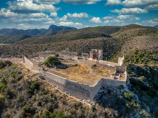 Fototapeta na wymiar Aerial view of Bairen medieval castle ruin near Gandia in Spain with partially restored circular towers with cloudy sky