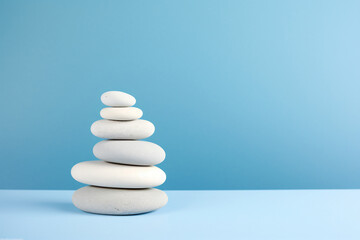 Fototapeta na wymiar Zen Stone Stack on a Serene Blue Gradient Background. Balance and Harmony Concept