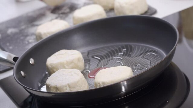 Cooking fried quark pancakes Syrniki. Pancakes are fried in a frying pan. Belarusian, Russian, Ukrainian cuisine.