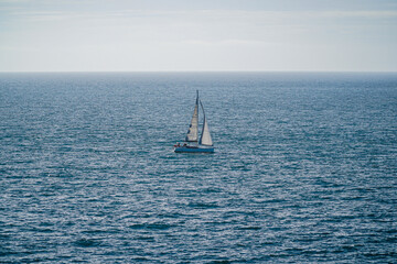 Sailboat glides across azure waves.