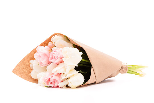 Bunch of white and pink double tulips wrapped in recycled brown paper isolated on white background. Tulips bouquet.