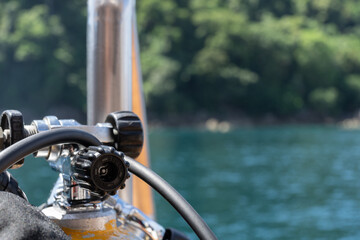 The head of a compressed air cylinder for diving from a liveaboard with the green of a island in...