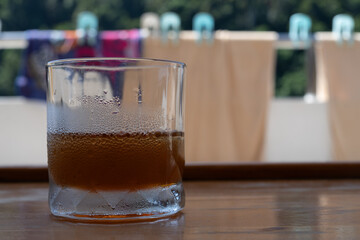 a cold glass of icetea with water droplets from condensation

