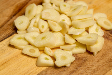 garlic on a wooden chopper in the kitchen ready to be added to food.