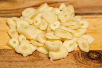 garlic on a wooden chopper in the kitchen ready to be added to food.