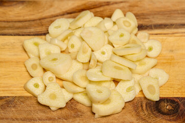 garlic on a wooden chopper in the kitchen ready to be added to food.