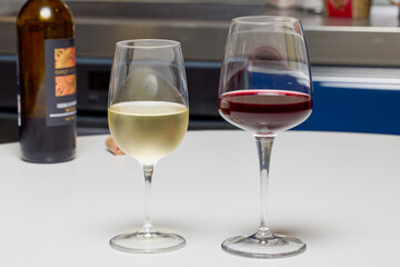 a glass of red wine and a glass of white wine on a table.