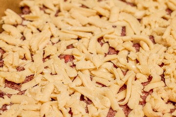 The hands of a woman preparing a traditional homemade dough cake in the kitchen.