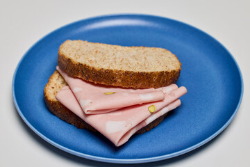slices of bread with mortadella on a plate.