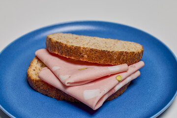 slices of bread with mortadella on a plate.