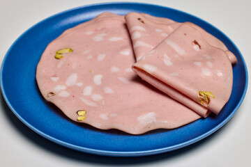 slices of bread with mortadella on a plate.