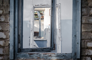 view from the window onto the walls, windows, doors of an abandoned house