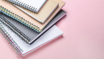 Different notebooks on light pink background, top view. Space for text