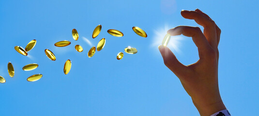 Flying Vitamin D Pills with Woman Hand in Summer Sun - Panorama