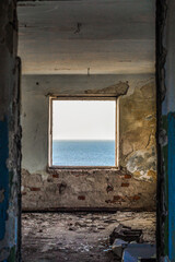 Fototapeta na wymiar sea horizon in the window of the destroyed room