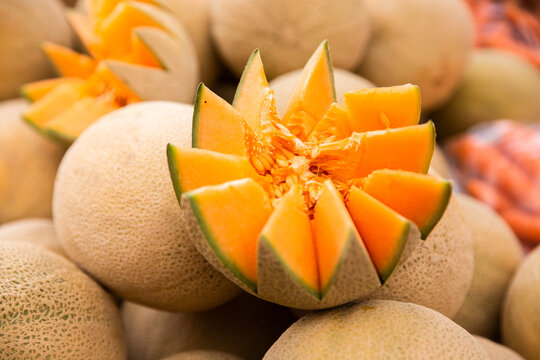 fresh rockmelon cut open on a pile of rockmelon