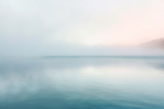 Foggy morning on the lake. Beautiful natural background. Long exposure. A minimalist photograph capturing the delicate dance of morning mist over a tranquil lake.