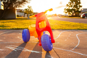 trike left behind at sunset on chalk path drawn on suburban driveway