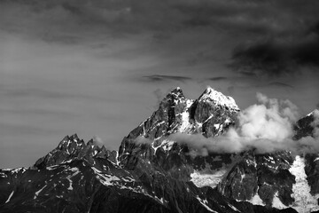Black and white mountains in clouds - 715613700
